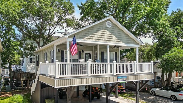 Ein eingeschossiges Haus mit Veranda, einer amerikanischen Flagge und einem Schild mit der Aufschrift 'Buch Haven'.
