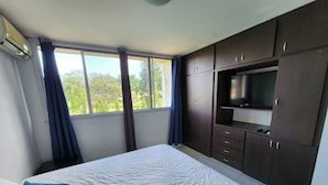 A bedroom with a bed, a TV, and a wardrobe.
