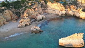 Un paysage côtier caractérisé par des formations rocheuses et une mer d’un bleu limpide.