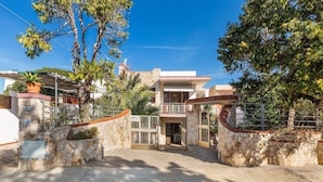 A two-story house with a stone facade, a gated entrance, and a covered porch. - 3214 Villa Serenè - Appartamento A by Barbarhouse (Racale)