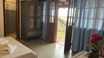 Una habitación con una cama, un armario de madera y una puerta que da a un espacio exterior.