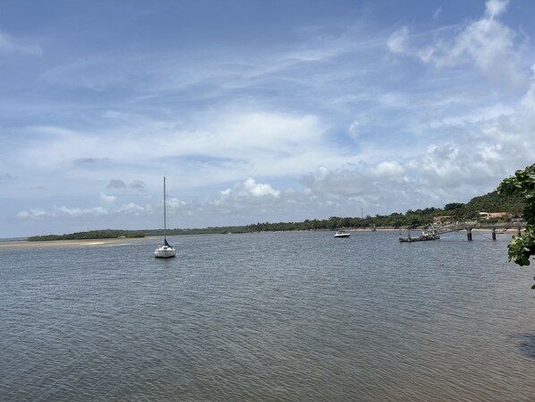 A calm waterfront with a sailboat, a dock, and a bridge. - Casa Oribà  (Santa Cruz Cabralia)