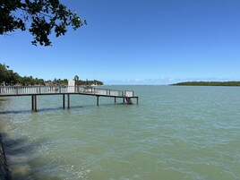 Un muelle que se adentra en aguas tranquilas bajo un cielo despejado.