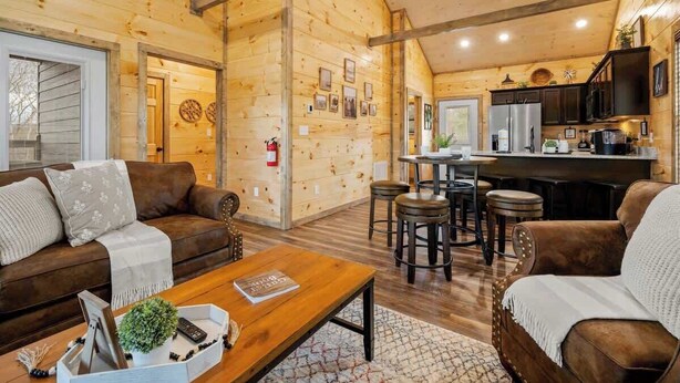 A cozy cabin interior with a wooden interior, a dining area, and a kitchen. - New Build! Hot Tub, Fireplace (Pigeon Forge)