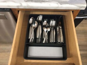 A drawer with a black tray containing various silverware. - Spacious Family Home with Indoor Hot Tub & Playset (Sioux Falls)
