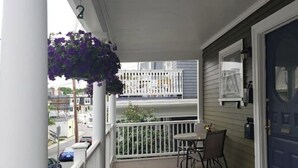 A balcony with a white railing, a table, and a chair. - Centrally located in the heart of Boston near T (Boston)