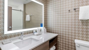 A bathroom with a white sink, mirror, and towel rack.
