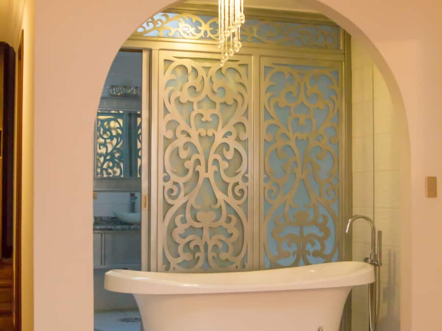 A bathroom with a freestanding bathtub, a shower, and a decorative wall panel.
