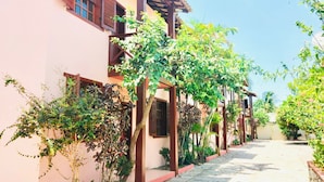 A narrow street with buildings on either side, featuring balconies and a tiled walkway. - Branca Tropical Brasil Residencial (Porto Seguro)