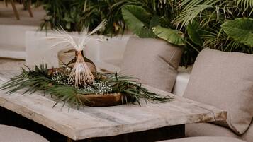 A wooden table with a decorative centerpiece, surrounded by cushioned seating.