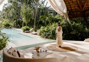Una piscina al aire libre, sombrillas, sillones reclinables de piscina