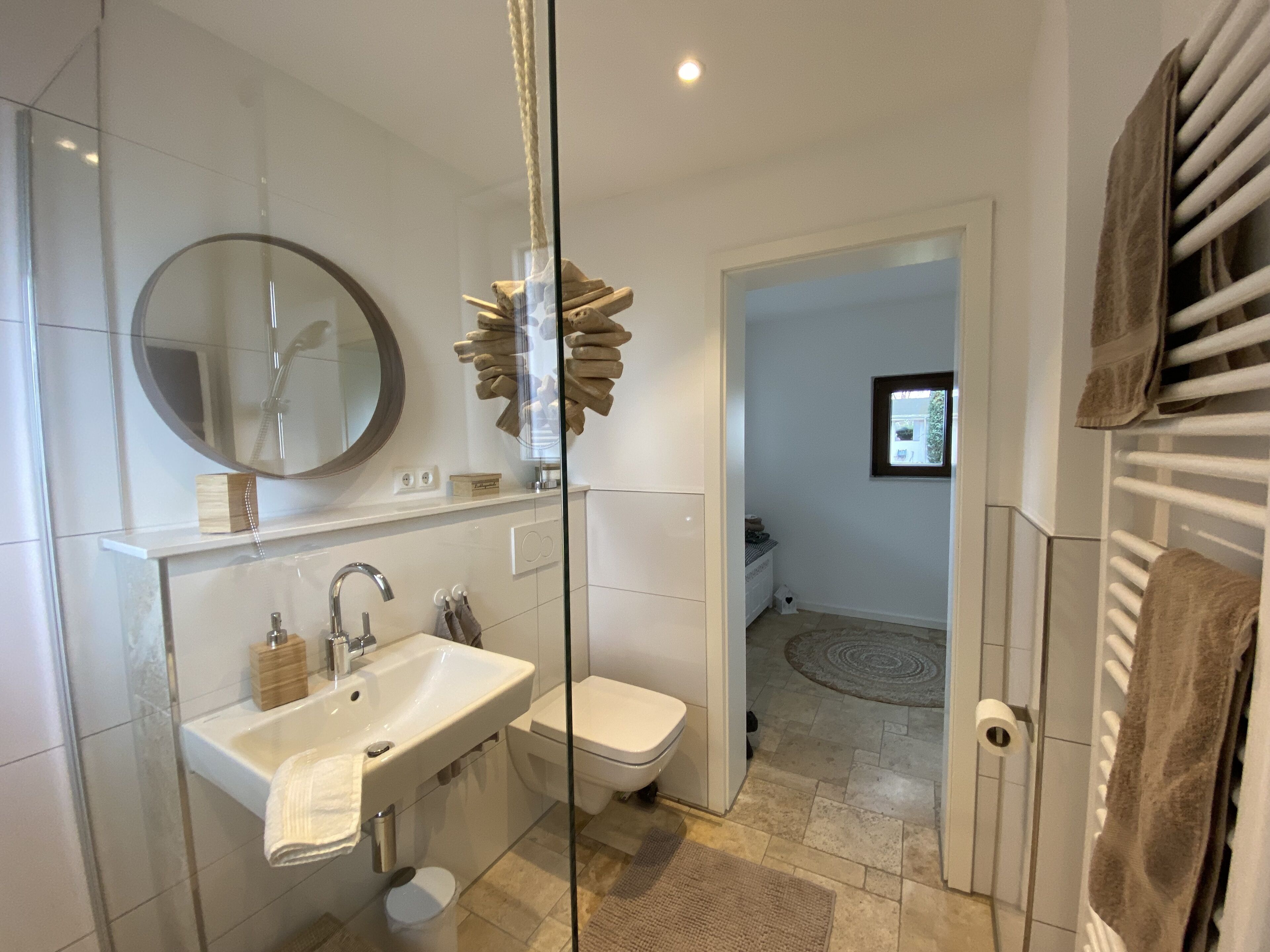 A modern bathroom with a glass shower enclosure, a white sink, and a toilet.