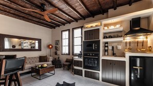 A modern kitchen with a built-in oven, a black refrigerator, and a wooden ceiling. - Domus Castrum (Νάξος)