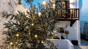 A white building with a balcony and a tree with lights. - Domus Castrum (Νάξος)