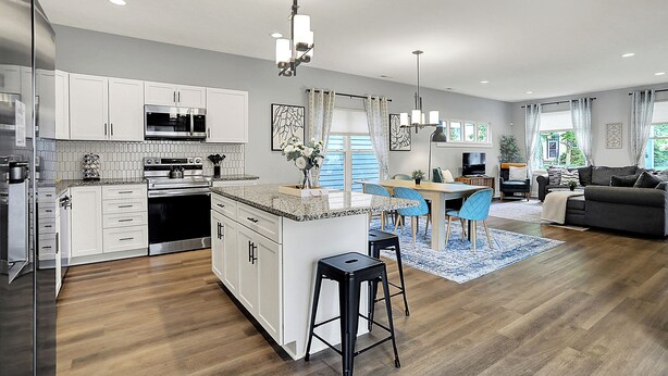 A modern kitchen with white cabinets, stainless steel appliances, and a central island. - Modern & Spacious Downtown Master Suite Palace! (Indianapolis)