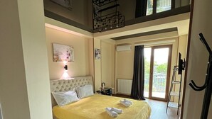Ein Schlafzimmer mit Bett, Nachttisch, Spiegel und Fenster.