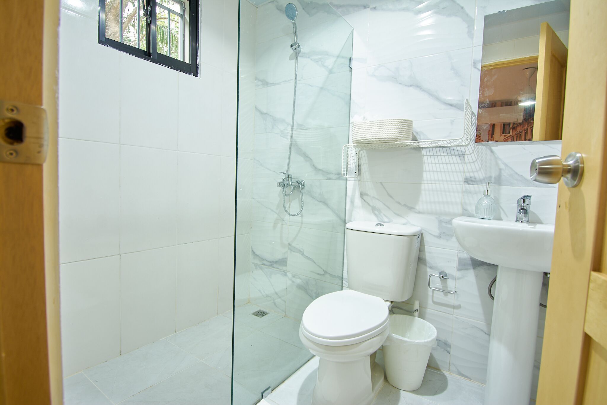 Une salle de bain comprenant une douche à parois de verre, des toilettes, un bidet et un lavabo.
