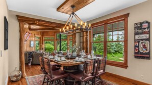 A dining area with a round table, wooden chairs, and a chandelier. - NEW! Sunsets Abound in Cross Lake Splendor (Crosslake)