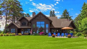 A large, two-story log cabin with a covered patio area. - NEW! Sunsets Abound in Cross Lake Splendor (Crosslake)