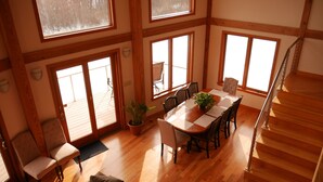 A spacious dining area with a wooden table, chairs, and a potted plant.