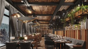 Un restaurant avec des plafonds en bois, des suspensions décoratives et une longue table à manger entourée de chaises.