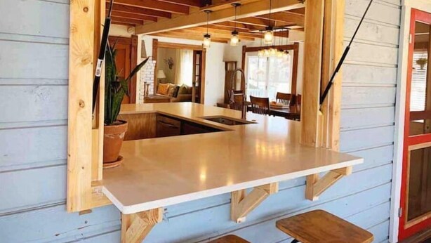A wooden-framed window with a built-in counter and bench seating.