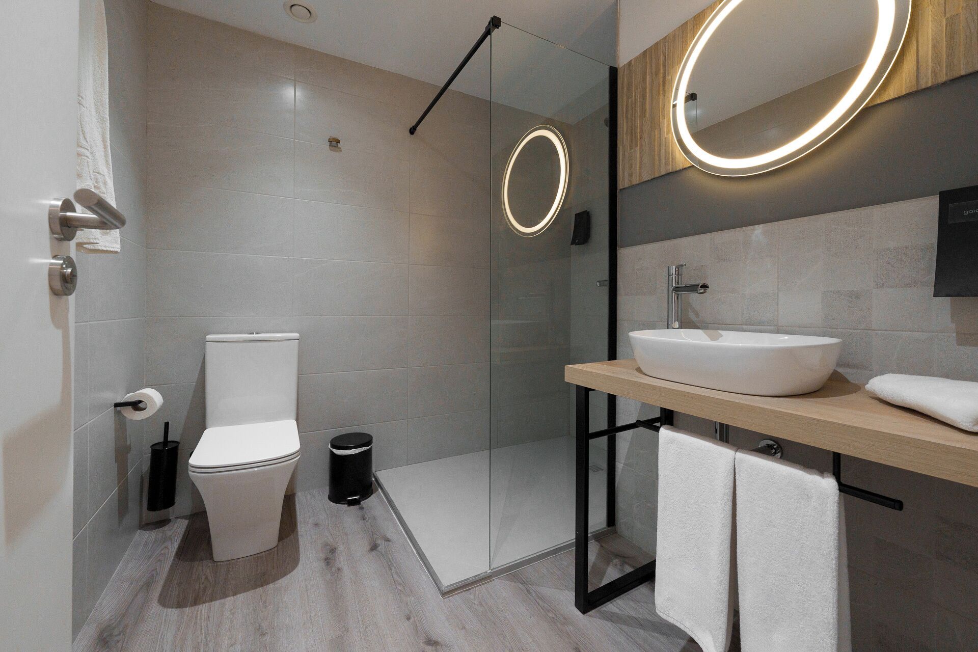 Une salle de bain moderne équipée de toilettes, d’un bidet et d’une douche à parois de verre.