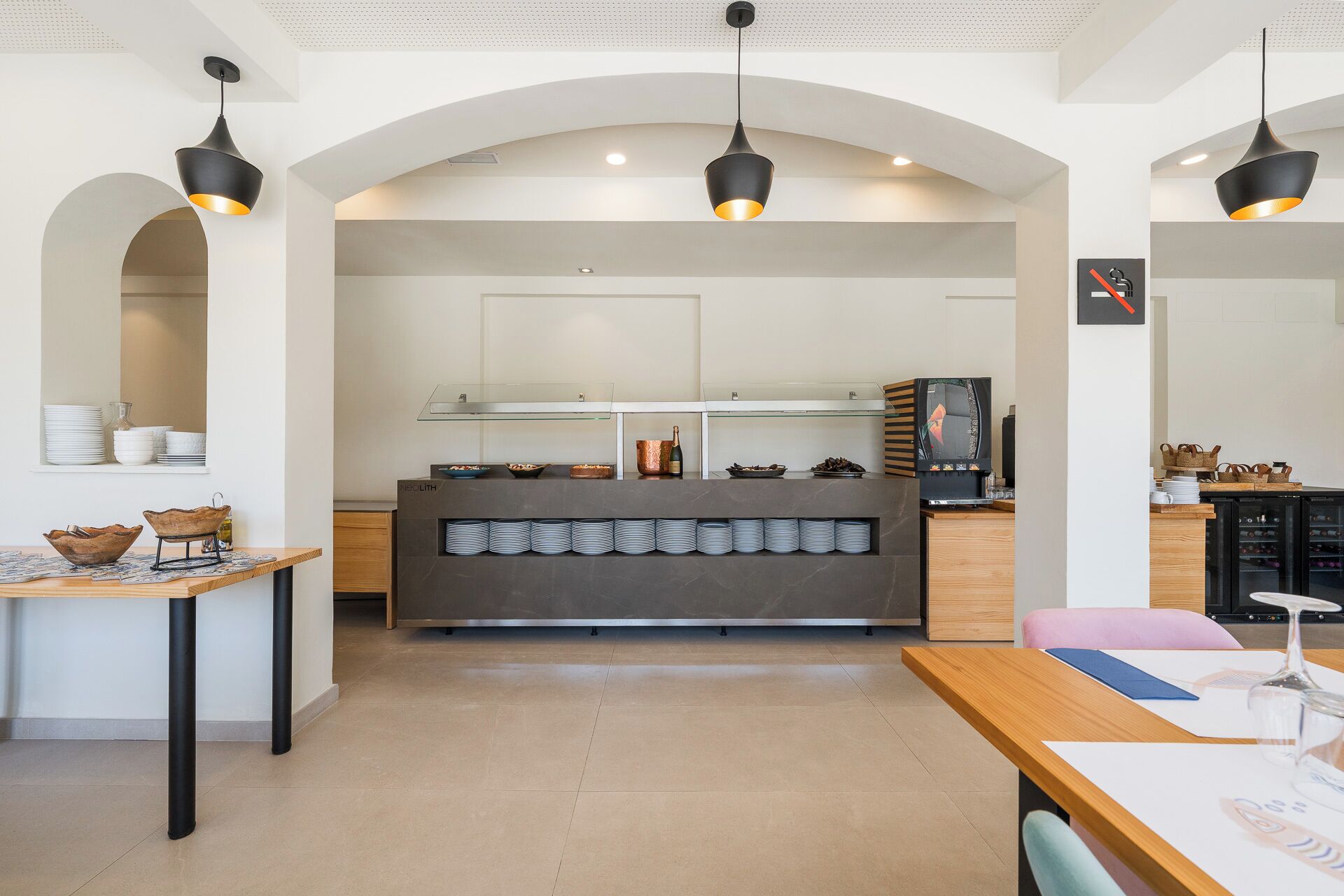A modern kitchen with a central island, pendant lights, and a coffee machine.