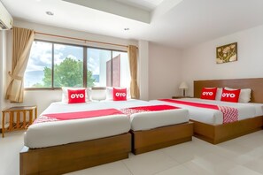 Camera d'albergo con due letti, un'ampia finestra e vista sull'esterno.