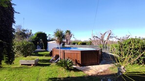 A backyard with a hot tub, a wooden deck, and a small garden area. - Villa Piana - Con Piscina ed Ampio Giardino Privato (Tricase)