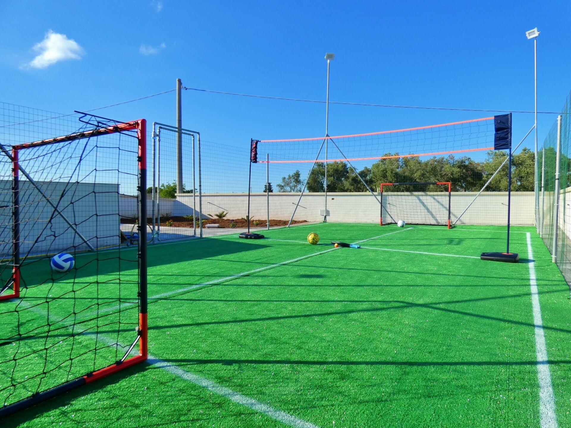 Un campo de fútbol con un arco, una red e izada de bandera.