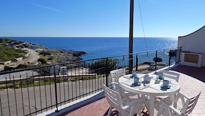 A balcony with a table set for two, overlooking a rocky coastline and the sea. - Corte del Mare - Dimora Fronte Mare nel Salento (Gagliano del Capo)
