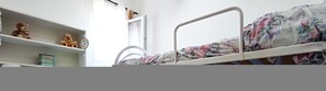 Cozy bedroom with a bunk bed featuring a lower metal frame and floral-patterned bedspread.