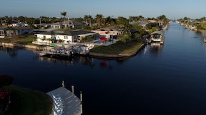 A residential area with a canal, houses, and a dock with boats.