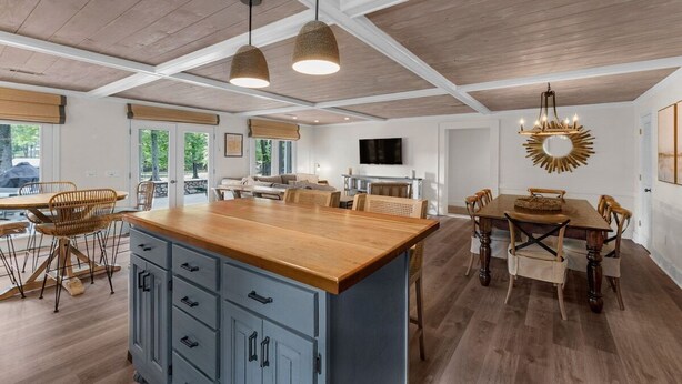 Una cocina amplia con armarios de madera, una isla central e iluminación colgante.