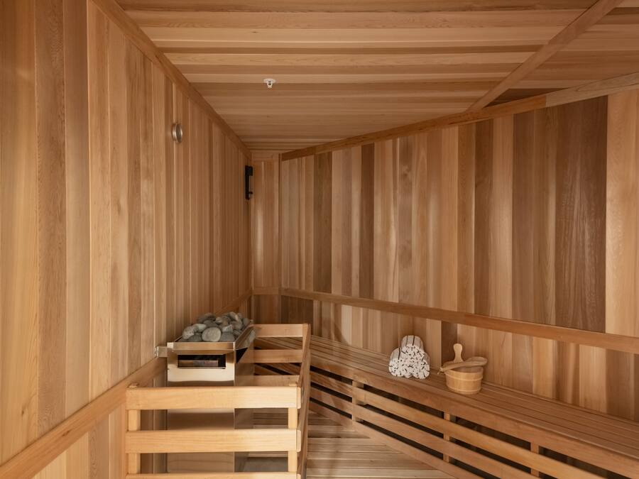 Una sauna de madera con bancos y una pequeña mesa con toallas.