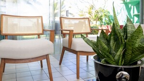 A seating area with two wicker chairs and a potted plant.