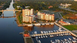 A marina with boats docked, a bridge, and residential buildings with balconies. - Beautiful Waterfront Condo in the Luxurious Four Star Hotel-7th Floor (Myrtle Beach)