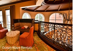 A spacious living area with a curved balcony, a sofa, ottoman, and a chair. - Beautiful Waterfront Condo in the Luxurious Four Star Hotel-7th Floor (Myrtle Beach)