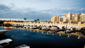 A marina with boats docked, a bridge, and a hotel in the background. - Beautiful Waterfront Condo in the Luxurious Four Star Hotel-7th Floor (Myrtle Beach)