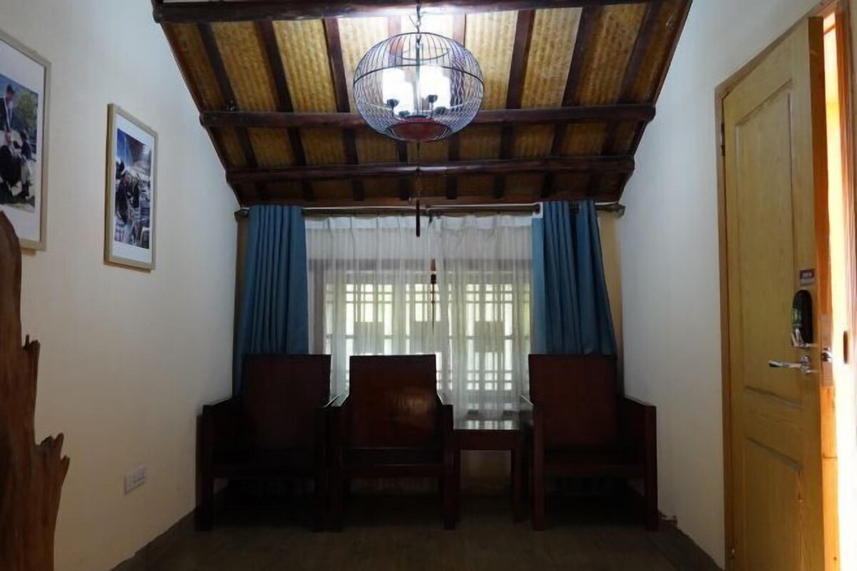 A dining area with a wooden ceiling, a chandelier, and a table with chairs.