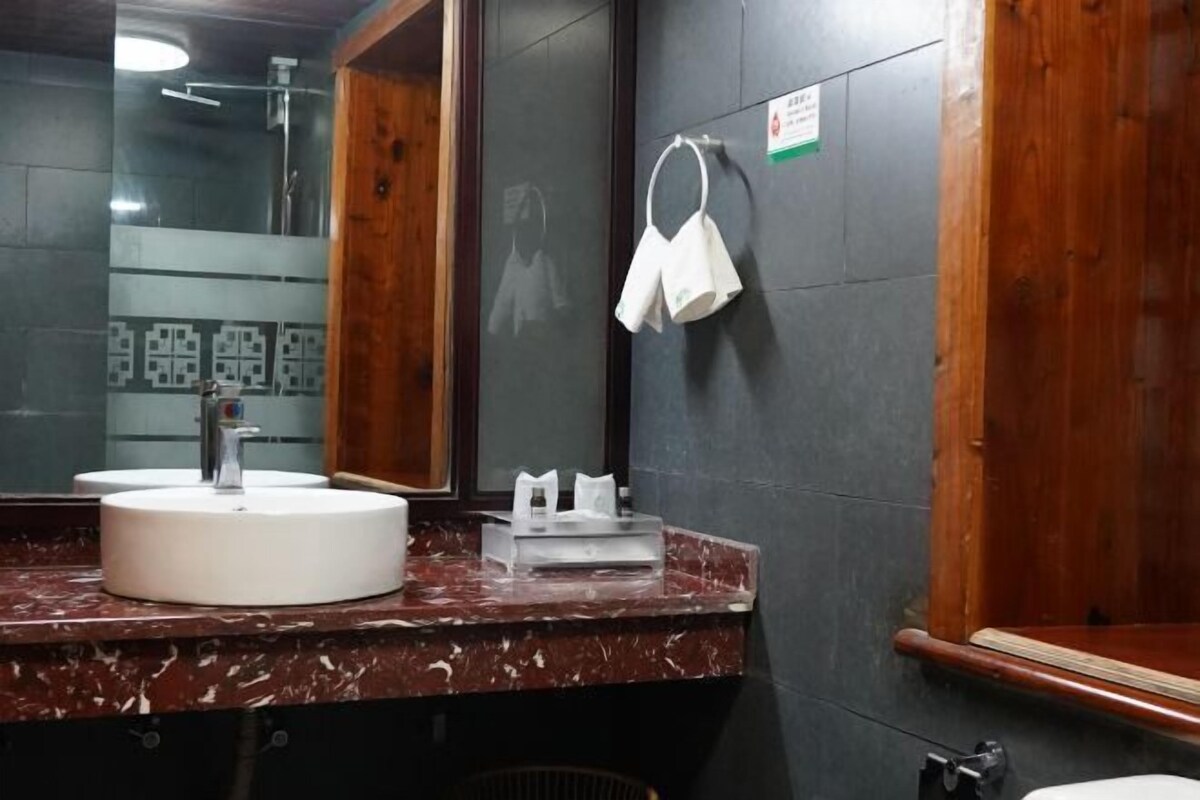 A bathroom with a marble sink, a mirror, and a towel rack.