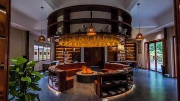 A modern interior with a circular seating area, bookshelves, and a central fire feature.