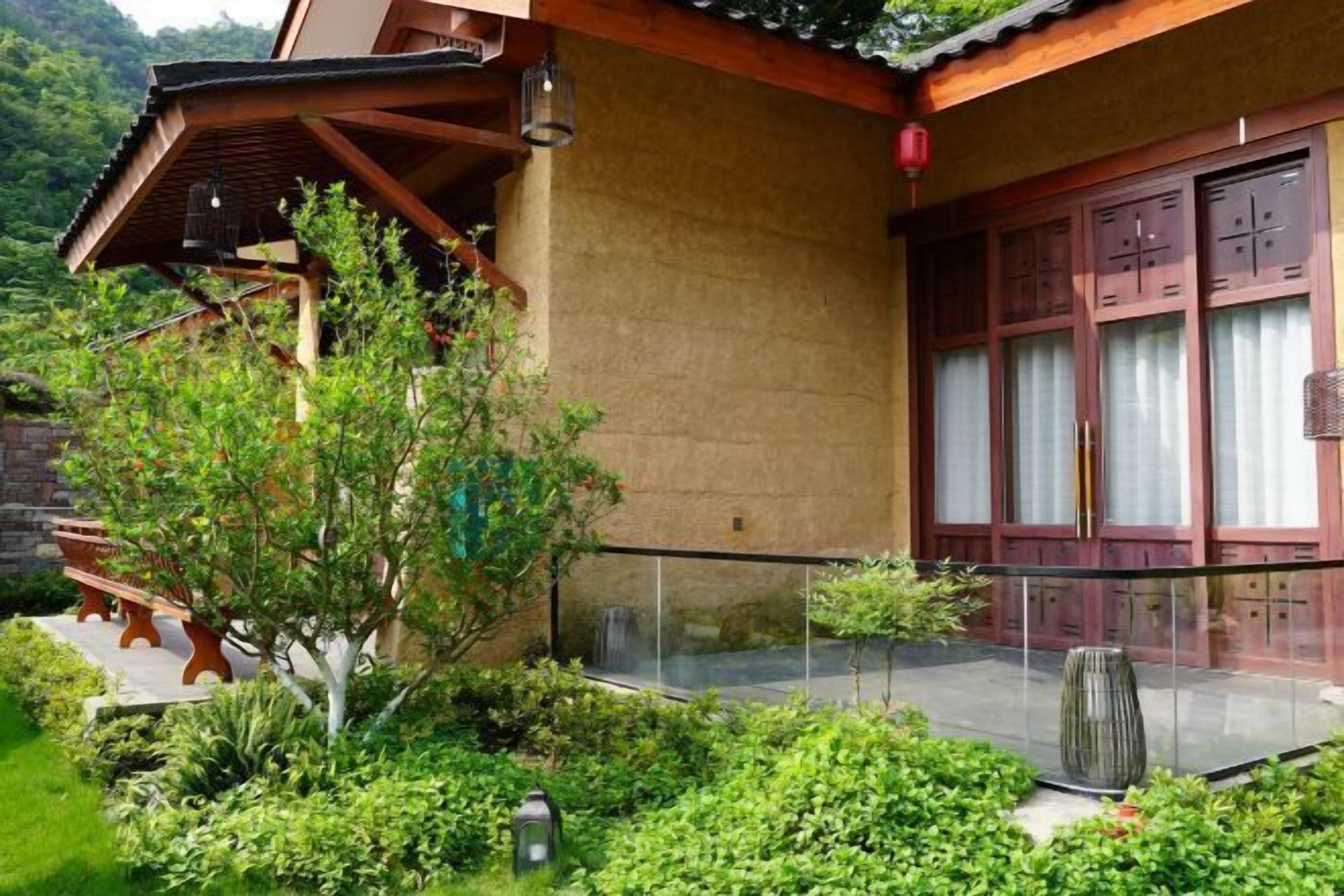 A traditional building with a wooden balcony, a stone wall, and a glass door.