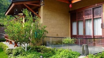 A traditional building with a wooden balcony, a stone wall, and a glass door.
