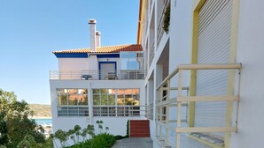A modern building with a two-story structure, a covered walkway, and a view of the sea. - 2 bedrooms beachfront (Vila Nova de Milfontes)