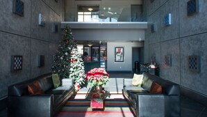 A lobby with two leather sofas, a Christmas tree, and a large window. - 7301 E. 3rd Avenue / UNIT #208 (Scottsdale)