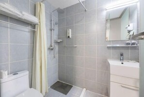A bathroom with a shower, toilet, sink, and a mirror. - Jinjiang Inn Wuqing Traditional Chinese Medical Hospital Hotel Tianjin (Tianjin)
