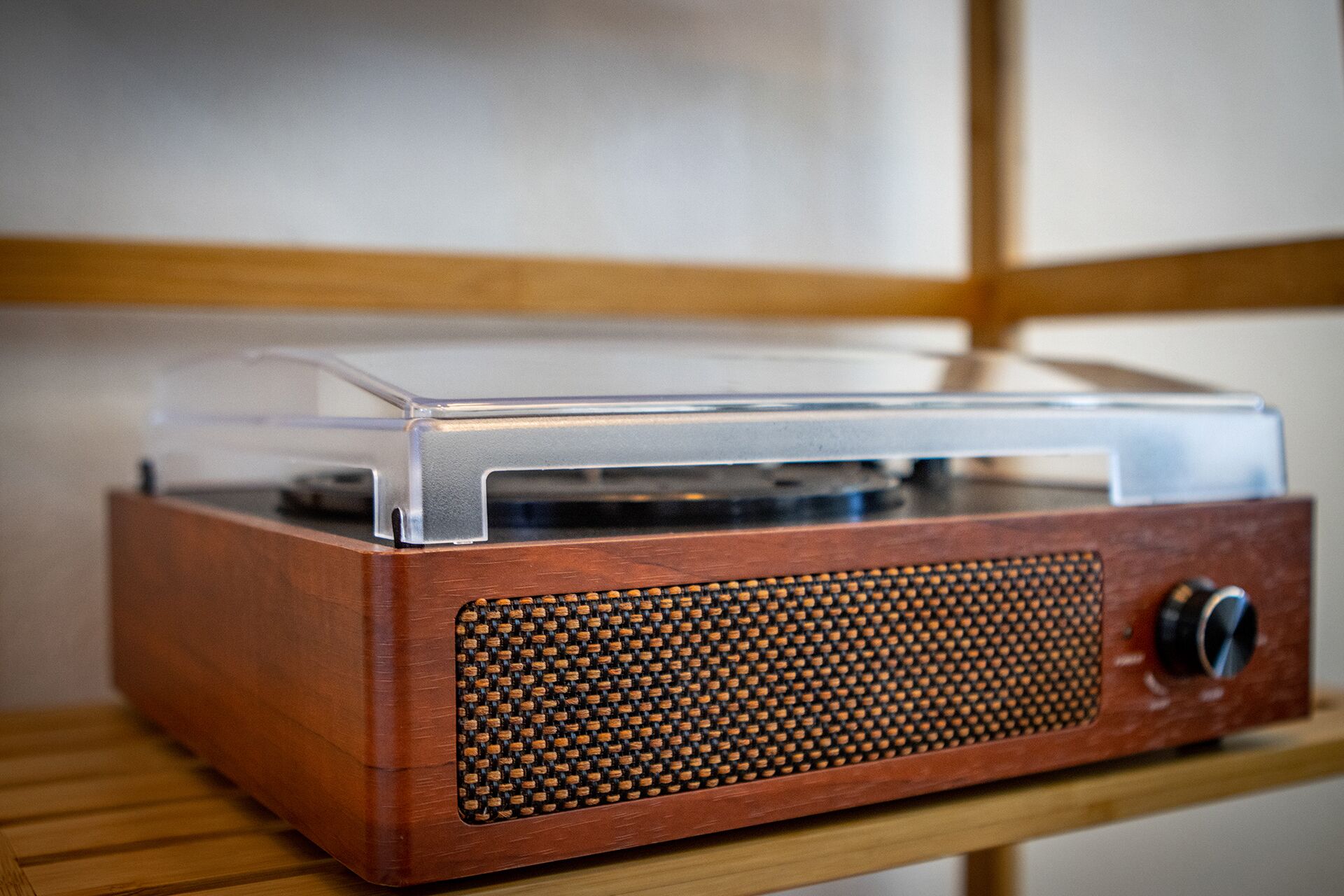 A vintage radio with a wooden finish and a clear plastic cover.