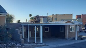 Un edificio de una planta con techo plano, un porche cubierto y un pequeño garaje adosado.